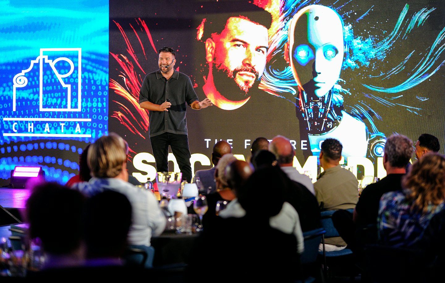 Prelegent występuje na scenie przed ekranem konferencji AI.